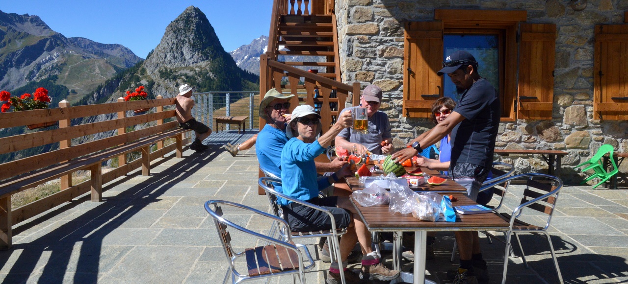 A group of hikers enjoying a packed lunch at the Bertone Hut, Italy